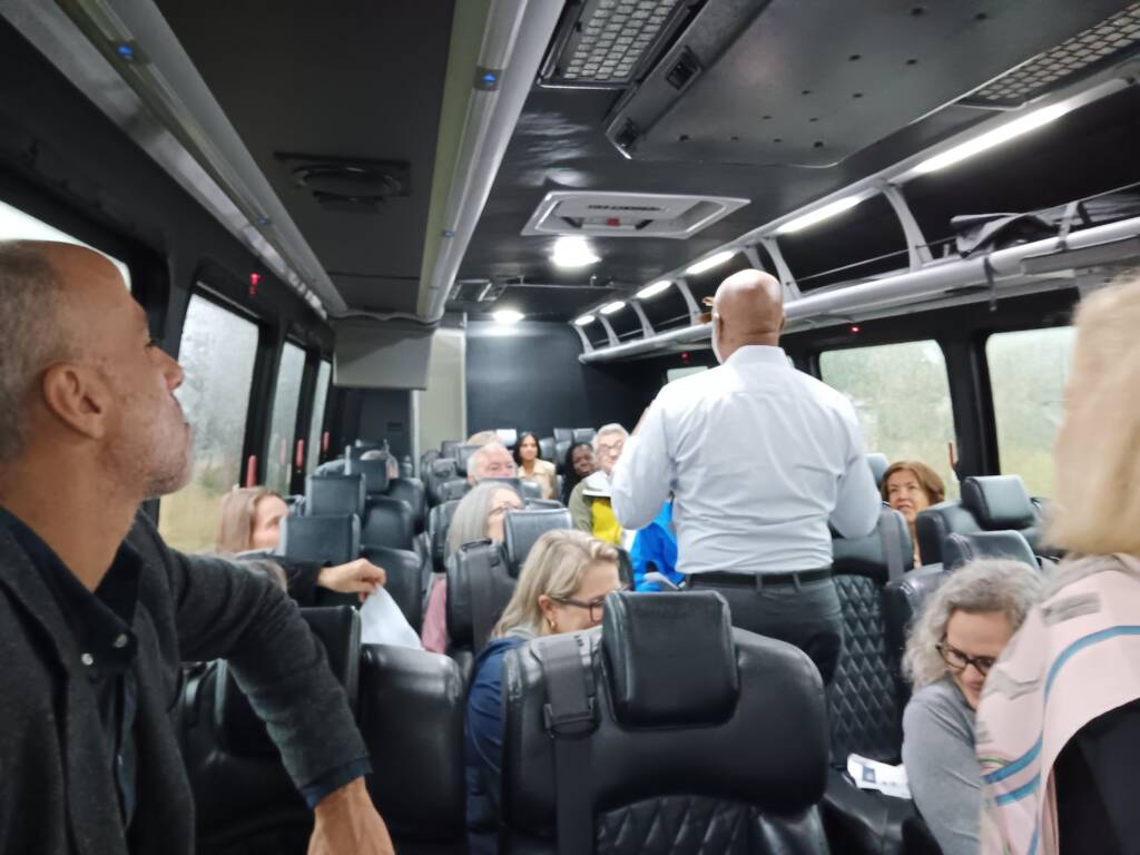 Scott Walker, CEO of 3Keys, speaks to Enterprise leadership and board during a bus tour of affordable housing developments.